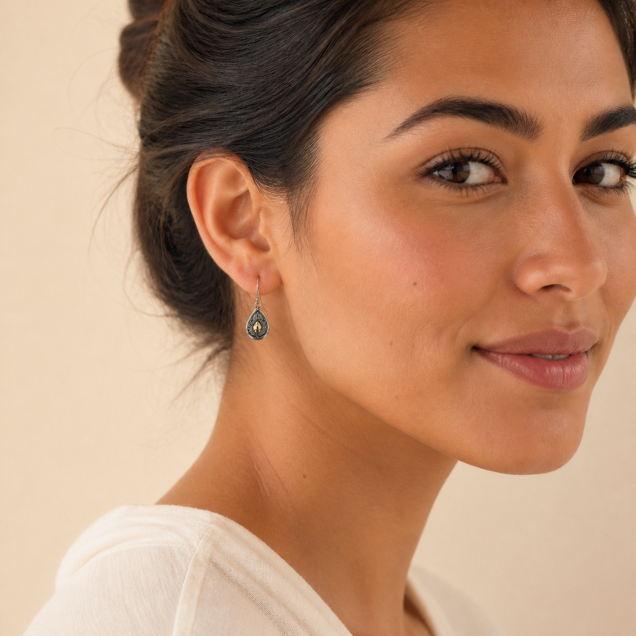 Young adult woman wearing small PJ Luxe Balinese-style silver earrings with 18ct gold accents