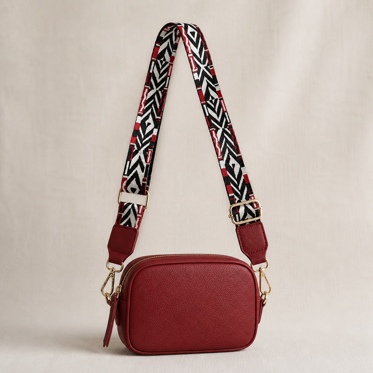 Crimson Tribal red-trim interchangeable strap styled on a red crossbody bag; bag not included