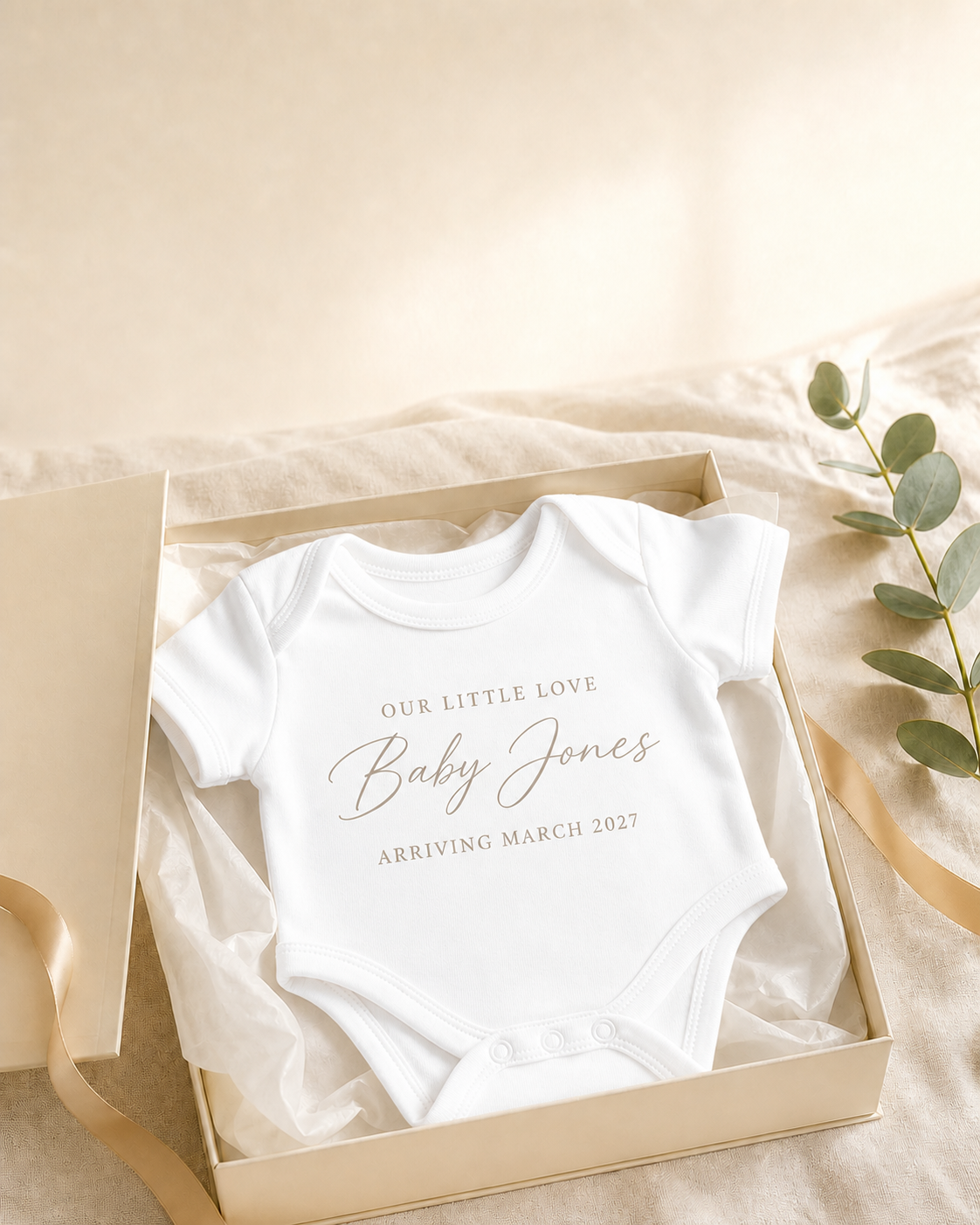 Concept launch image of a white personalised baby announcement bodysuit in PJ Luxe gift packaging