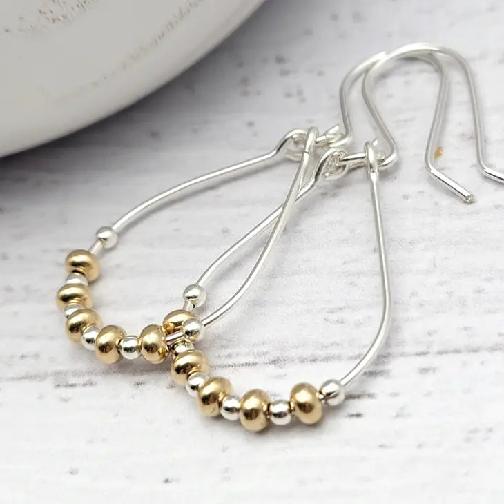 Pair of elegant teardrop earrings featuring a harmonious blend of 14K gold filled and sterling silver, designed with a polished finish for a sophisticated shimmer. Perfect accessory for both casual and formal outfits.