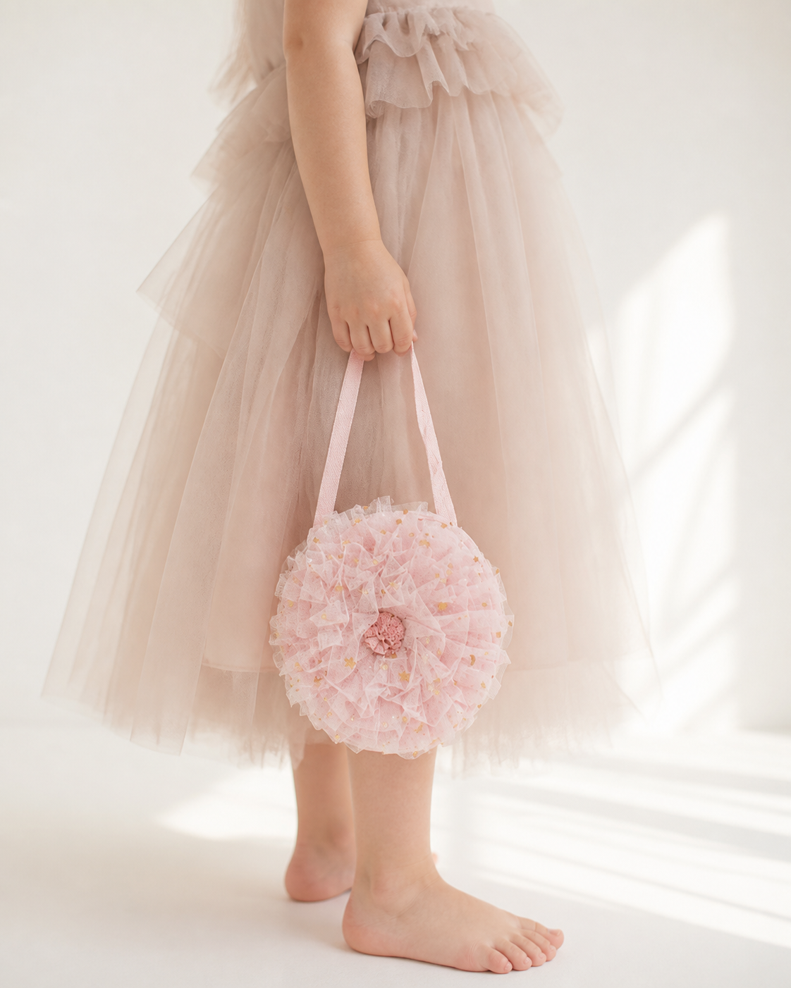 PJ Luxe champagne pink Pixie Dust tulle ruffle bag held with a blush tulle dress