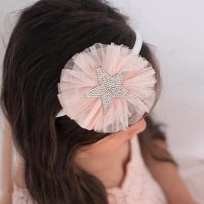 Girl's blush pink tulle hairband with a sparkling rhinestone star, set on a delicate band to add a whimsical and elegant touch to any outfit.