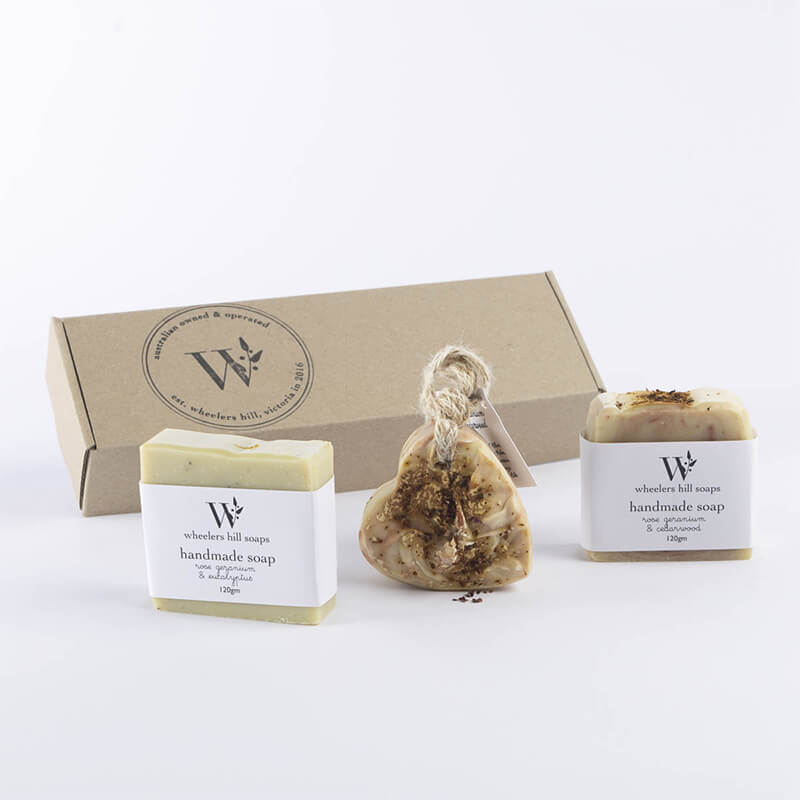 Eco-friendly gift box containing a selection of natural handmade soaps, crafted with organic ingredients and essential oils. Features various scents and colors, presented in a rustic, recyclable packaging, perfect for a thoughtful and sustainable gift.