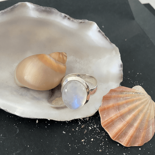 Elegant Sterling Silver Moonstone Ring featuring an oval-shaped, luminous moonstone set on a solid, sleek band. The moonstone's captivating play of light adds a touch of mystique, complemented by the sterling silver's enduring shine, making it a timeless piece for any collection.