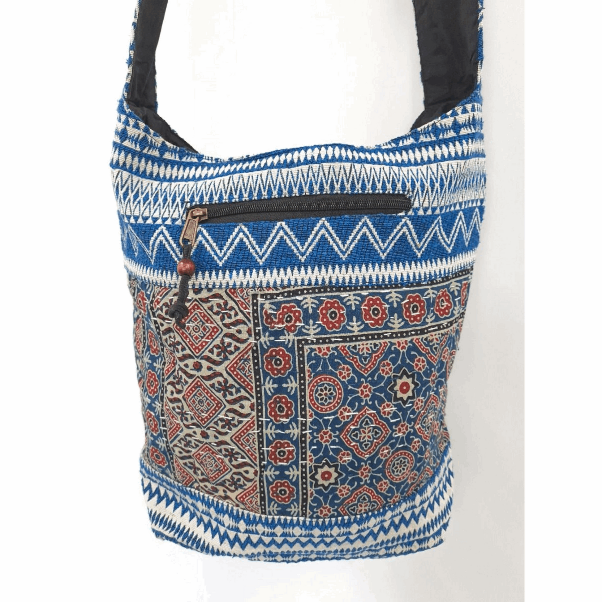 Bohemian-inspired cotton satchel bag with blue and red Indian print, featuring a front zippered pocket and a black shoulder strap for stylish and practical daily use.