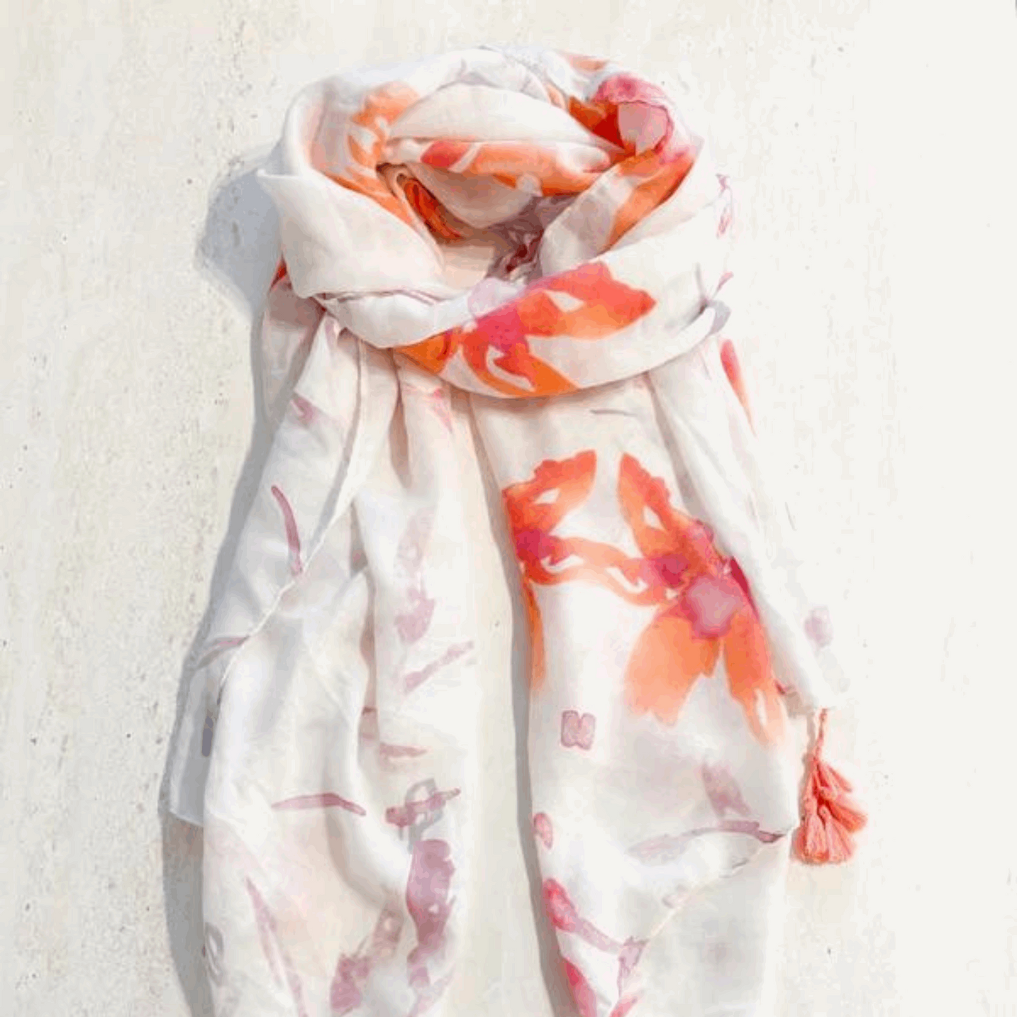 Delicate lightweight scarf adorned with a vibrant watercolor floral print, featuring soft pastel hues on a sheer fabric. Perfect for adding a touch of elegance and color to any spring or summer outfit.