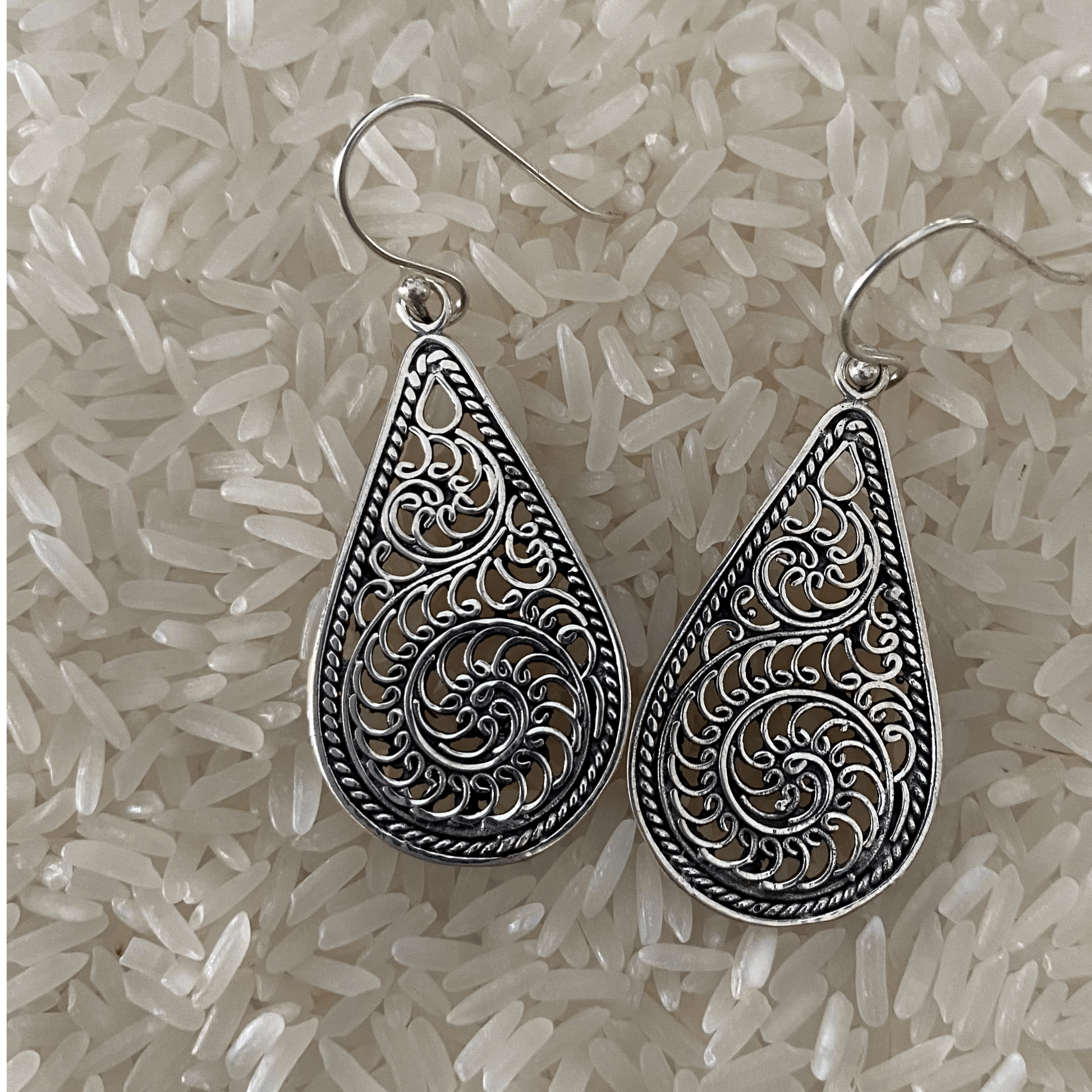 Delicate Sterling Silver Filigree Teardrop Earrings, showcasing an intricate lace-like design within a teardrop shape, offering a blend of elegance and vintage charm, perfect for adding a sophisticated touch to any outfit.