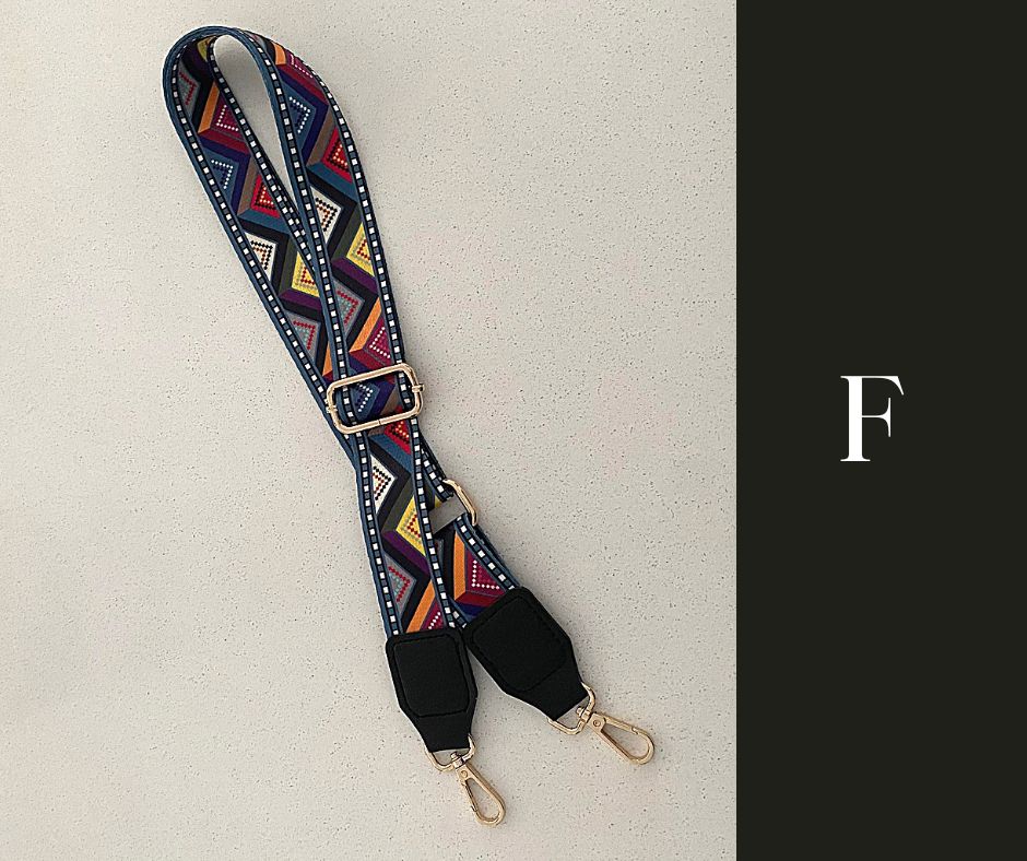The image showcases a collection of Luxe Bohemian Guitar Style Shoulder Straps laid out horizontally. Each strap is adorned with vibrant, intricate patterns, featuring a mix of geometric shapes and vivid colors that exude a bohemian aesthetic. The straps are finished with sturdy hardware, suggesting a functional yet fashionable accessory designed to complement and enhance a variety of handbags or travel items. The overall presentation is rich and colorful, aligned with a luxurious and eclectic style