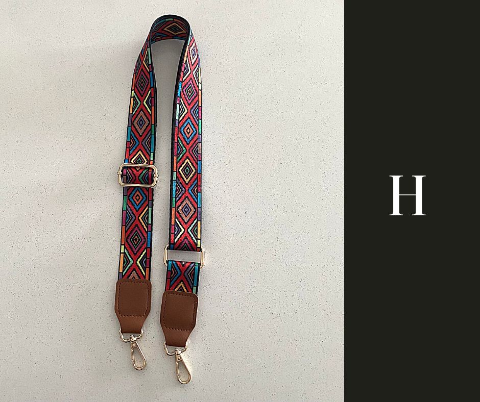 The image showcases a collection of Luxe Bohemian Guitar Style Shoulder Straps laid out horizontally. Each strap is adorned with vibrant, intricate patterns, featuring a mix of geometric shapes and vivid colors that exude a bohemian aesthetic. The straps are finished with sturdy hardware, suggesting a functional yet fashionable accessory designed to complement and enhance a variety of handbags or travel items. The overall presentation is rich and colorful, aligned with a luxurious and eclectic style