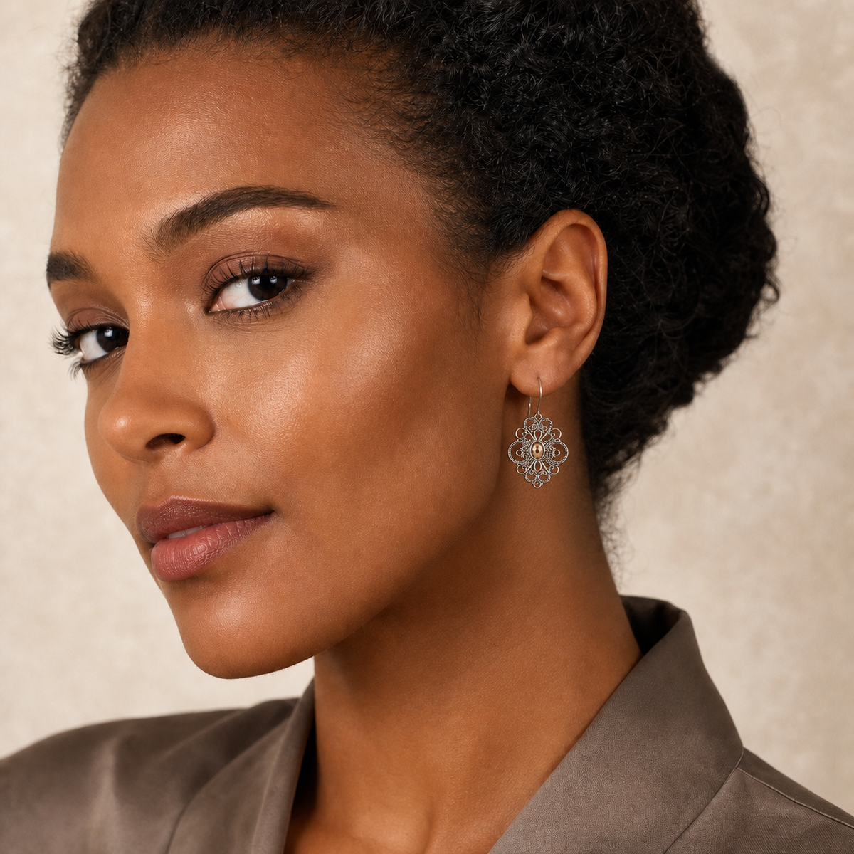 Young adult woman wearing small PJ Luxe sterling silver filigree flower earrings with rose gold accents