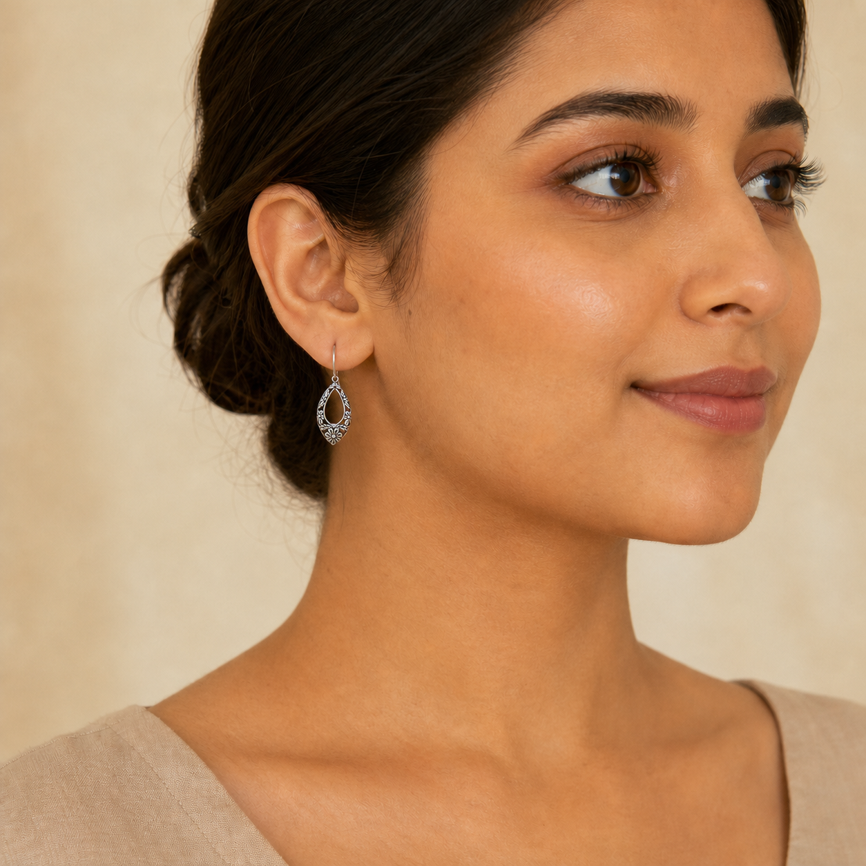 Young adult woman wearing small PJ Luxe sterling silver floral pattern earrings
