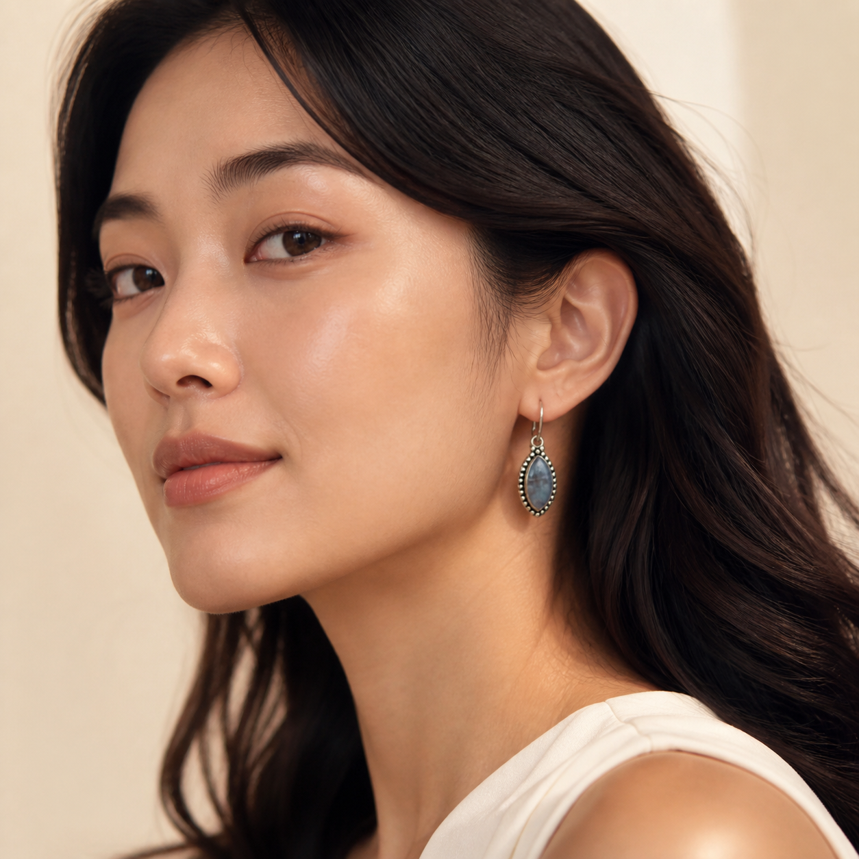 Young adult woman wearing PJ Luxe moonstone teardrop sterling silver earrings