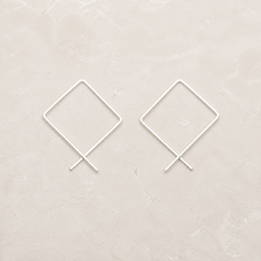 Sterling silver square threader hoop earrings on a warm ivory background