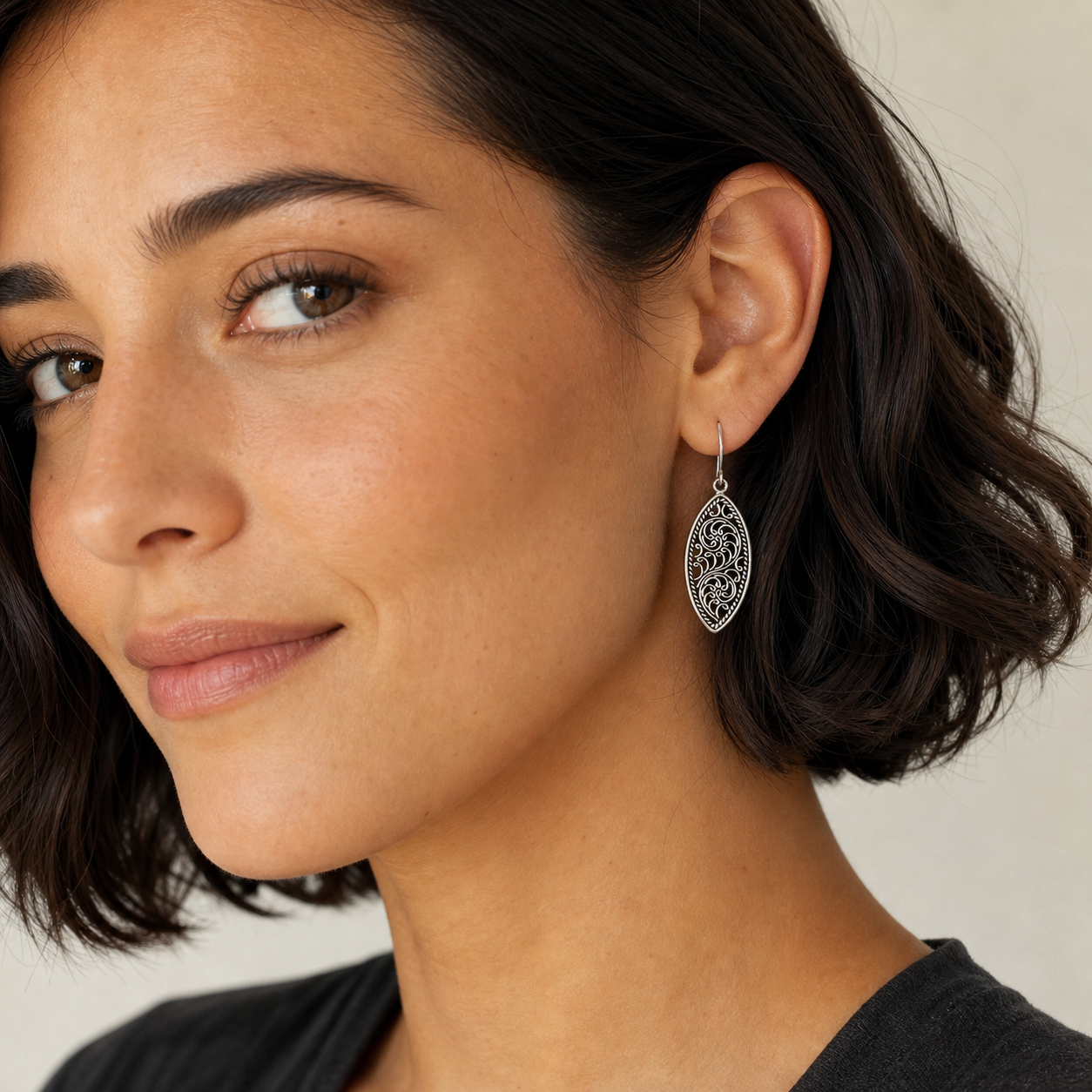 Woman wearing PJ Luxe sterling silver swirl filigree drop earrings