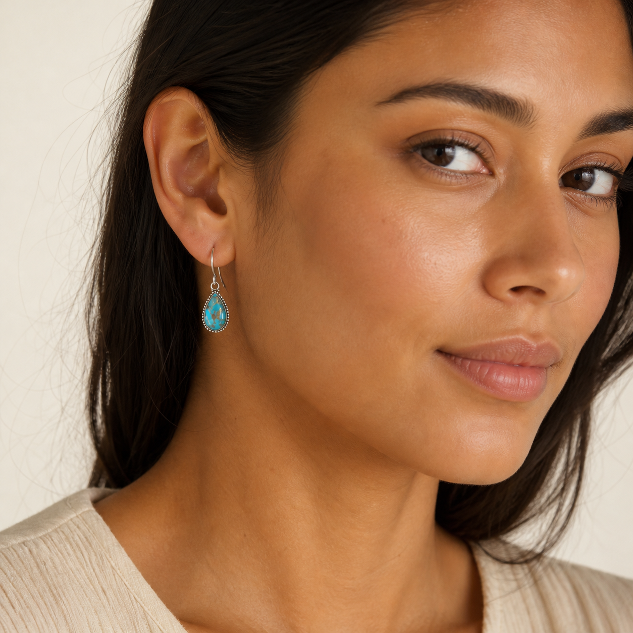 Woman wearing PJ Luxe sterling silver turquoise teardrop earrings