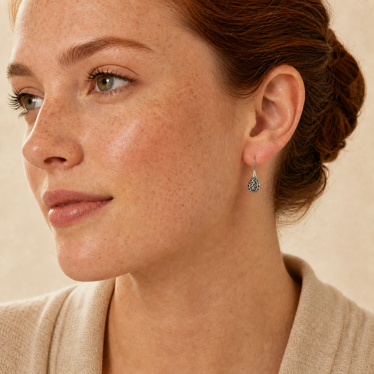 Young adult woman wearing small PJ Luxe sterling silver scrollwork teardrop earrings