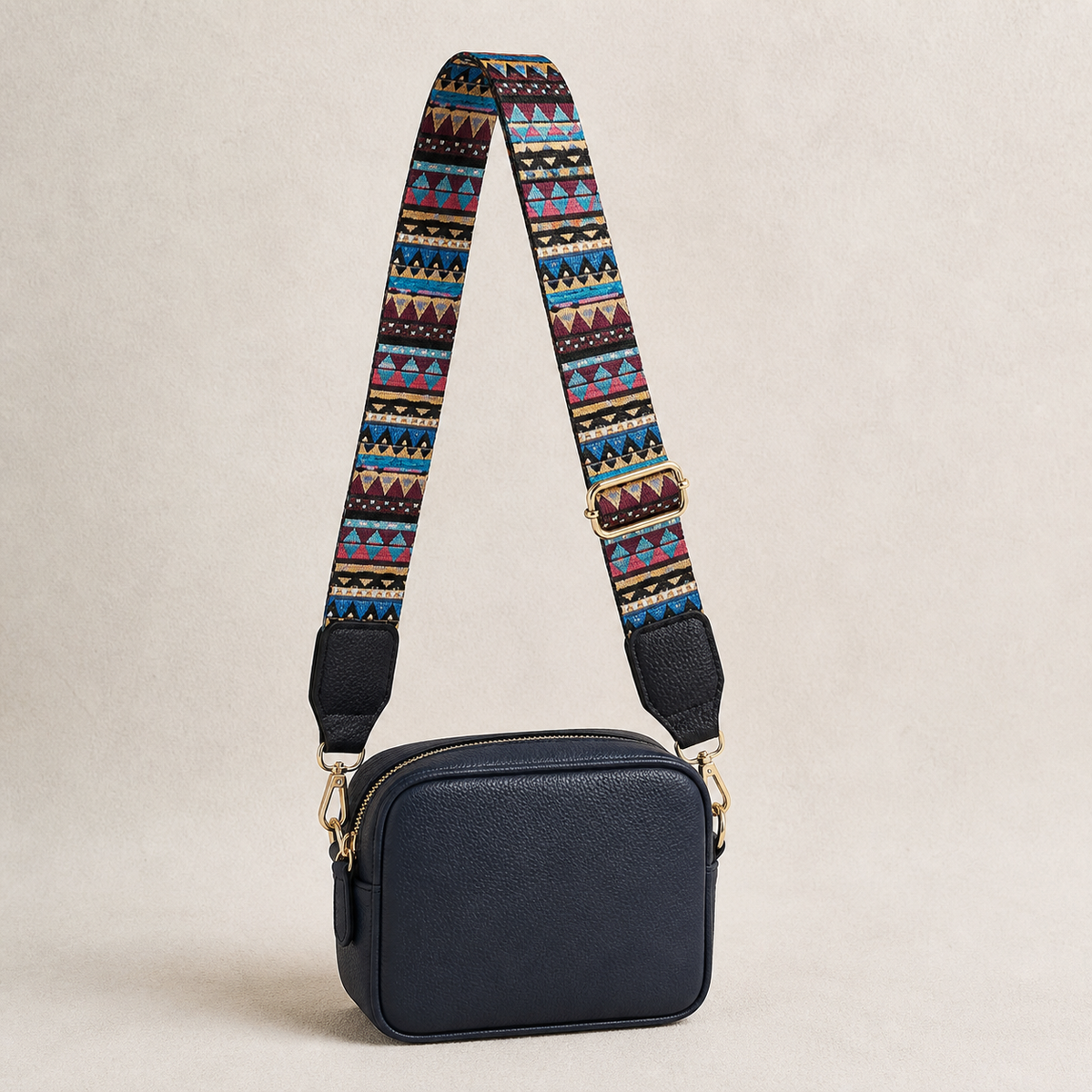 Sunset Aztec interchangeable strap styled on a navy crossbody bag; bag not included