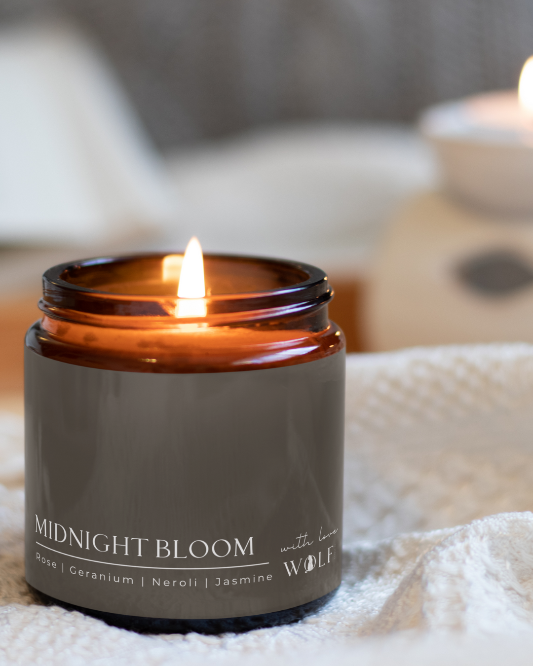 Midnight Bloom candle styled in a warm bedroom setting